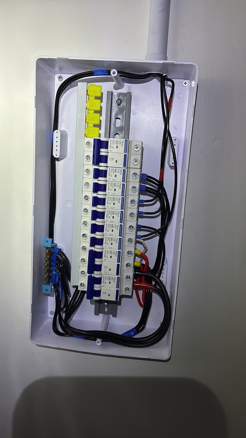 Quadro de disjuntores branco aberto, com fiação organizada